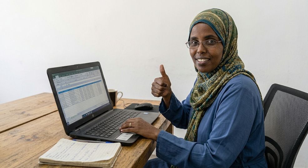 A data analyst giving a thumbs-up while working on a spreadsheet